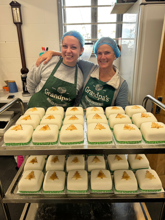 “Handmade corporate fruit cakes by Grandpa’s Cakes in branded boxes with ribbons and company logos, perfect for business gifts.”