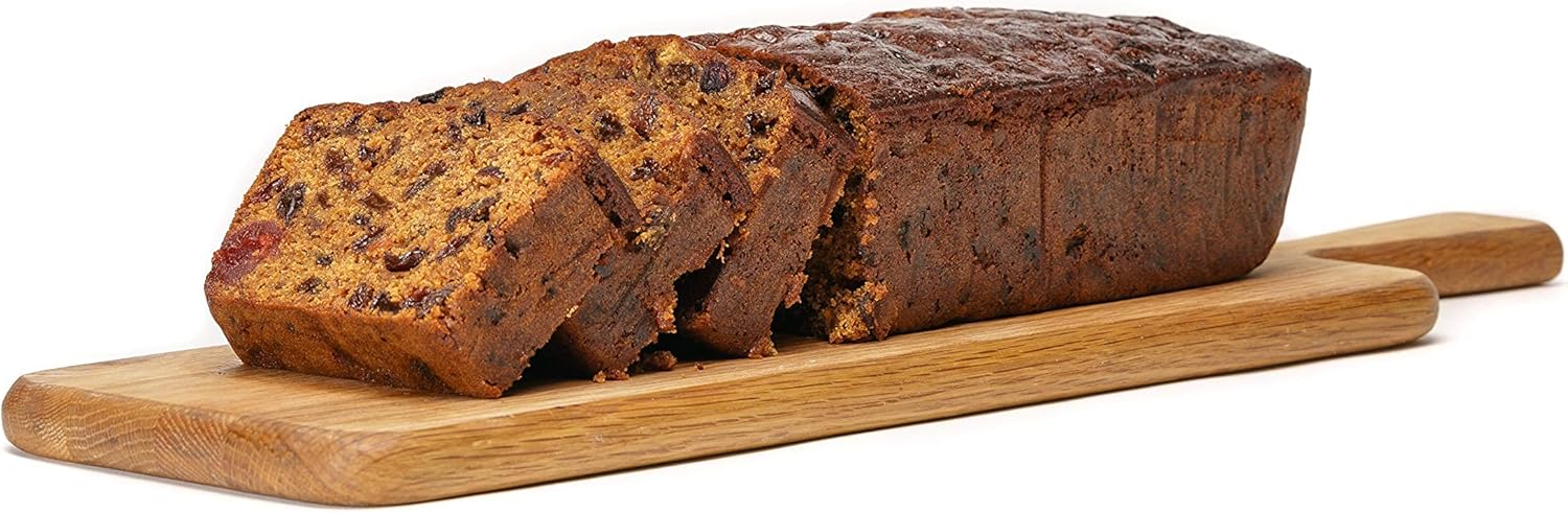 Classic fruit cake bar sliced on a wooden serving board, showing rich dried fruit texture, handmade by Grandpa’s Cakes