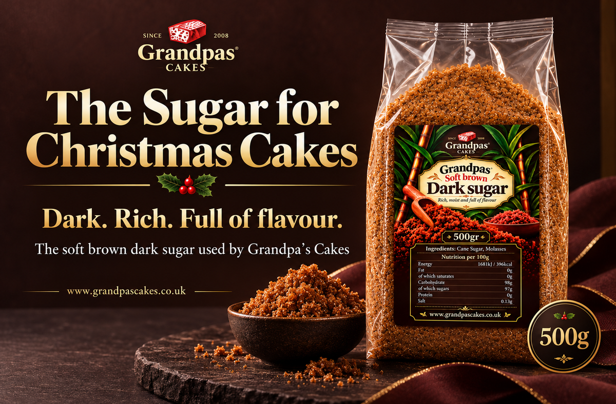 A 500g bag of Grandpas Cakes Dark Sugar displayed on a dark wooden surface next to a small bowl of the brown sugar. The background is a dark brown with promotional text reading 'The Sugar for Christmas Cakes'.